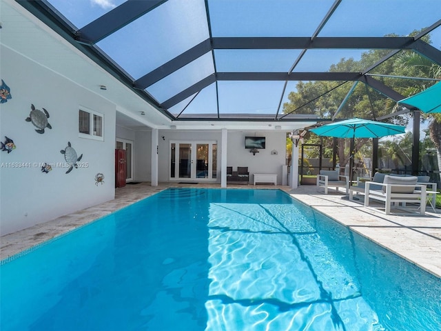 pool featuring glass enclosure, a patio, and french doors