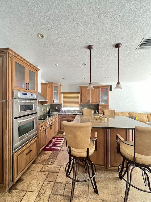 kitchen featuring pendant lighting, a textured ceiling, and double oven