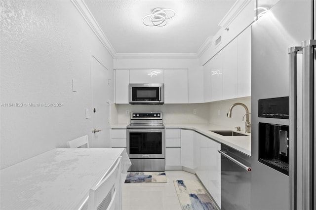 kitchen featuring light tile patterned floors, appliances with stainless steel finishes, sink, and white cabinetry