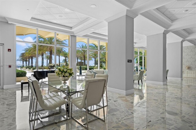 interior space with coffered ceiling, a tray ceiling, ornamental molding, a high ceiling, and floor to ceiling windows