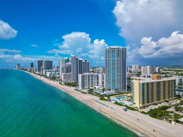 drone / aerial view with a city view, a view of the beach, and a water view