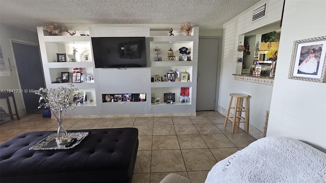 living room featuring a textured ceiling, built in shelves, and tile patterned floors