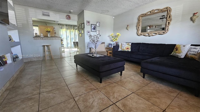 living room with a textured ceiling and tile patterned flooring