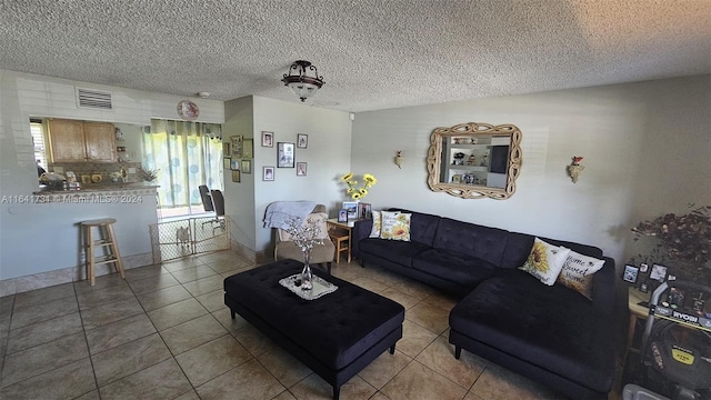 living room featuring a textured ceiling and tile patterned floors