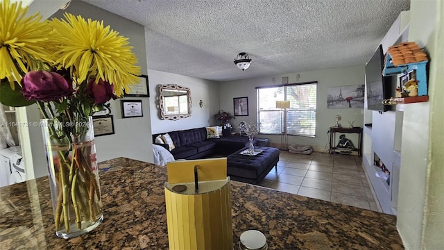 tiled living room featuring a textured ceiling