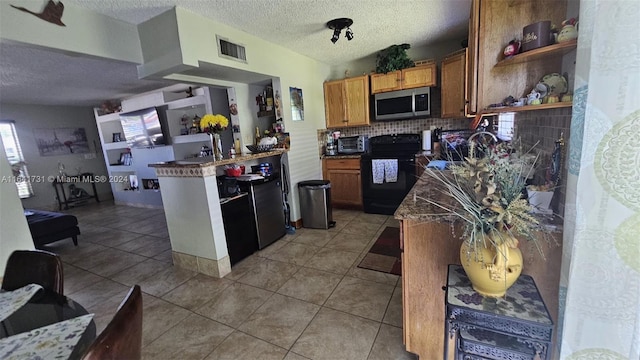 kitchen featuring light tile patterned flooring, a textured ceiling, tasteful backsplash, and black range with electric stovetop