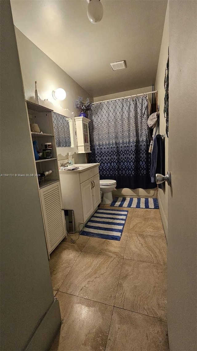 bathroom featuring vanity, toilet, and tile patterned flooring