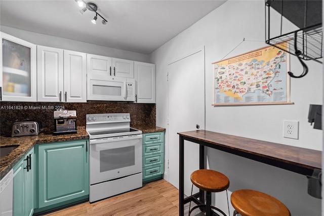 kitchen featuring light hardwood / wood-style flooring, backsplash, white cabinets, track lighting, and white appliances