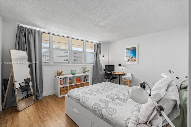 bedroom featuring light wood-type flooring and a textured ceiling