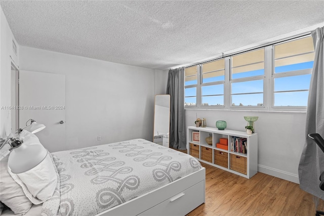 bedroom featuring a textured ceiling and light wood-type flooring