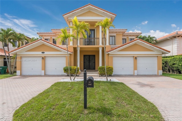 view of front of property featuring a garage, a front lawn, and a balcony