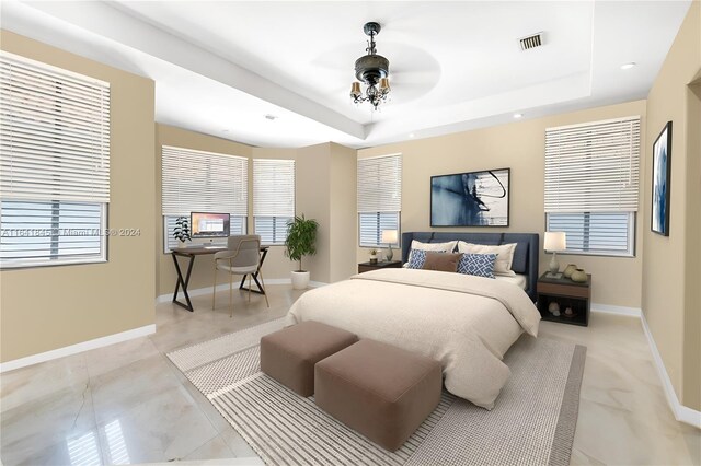 bedroom with light tile patterned flooring, ceiling fan, and a raised ceiling