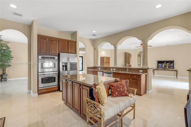 kitchen with kitchen peninsula, sink, stainless steel appliances, and light tile patterned floors