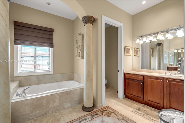 bathroom featuring decorative columns, toilet, tile patterned flooring, tiled tub, and vanity