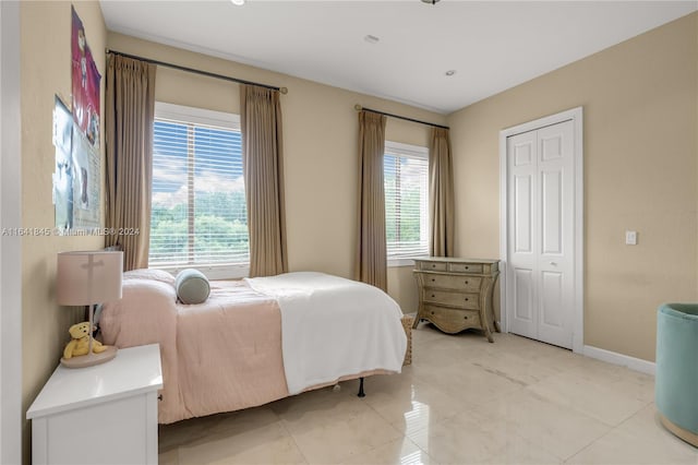 bedroom with light tile patterned flooring and a closet