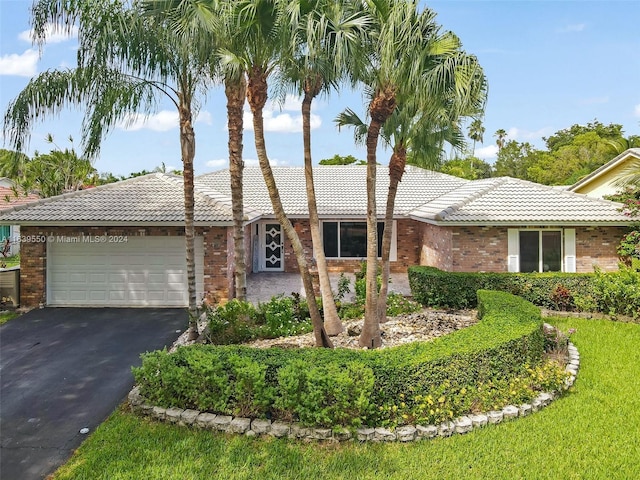 ranch-style house featuring a garage and a front yard