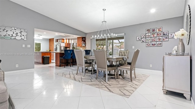 tiled dining space with vaulted ceiling and an inviting chandelier