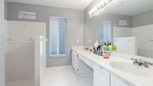 bathroom with vanity, a tile shower, and tile patterned floors