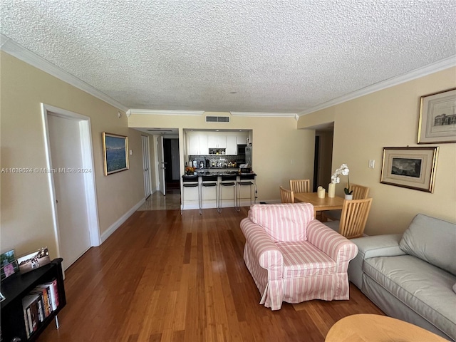 living room featuring a textured ceiling, hardwood / wood-style flooring, and crown molding