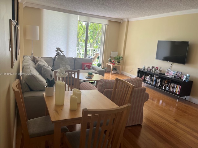 dining space featuring hardwood / wood-style flooring, ornamental molding, and a textured ceiling