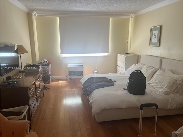 bedroom featuring crown molding, wood-type flooring, and a textured ceiling