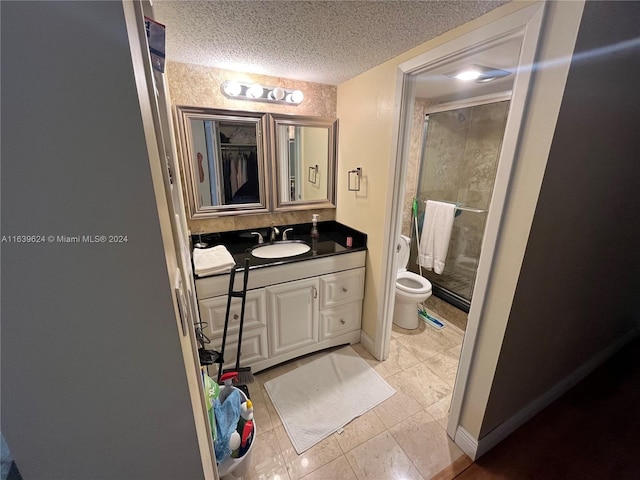 bathroom with vanity, tile patterned flooring, toilet, a textured ceiling, and an enclosed shower