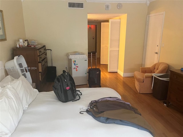 bedroom featuring ornamental molding and light wood-type flooring