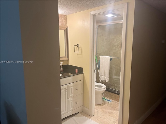 bathroom featuring tile patterned floors, a textured ceiling, toilet, a shower with door, and vanity