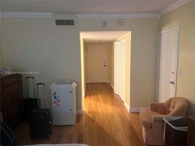 hallway featuring light hardwood / wood-style floors and ornamental molding