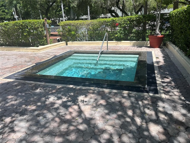 view of pool with an in ground hot tub