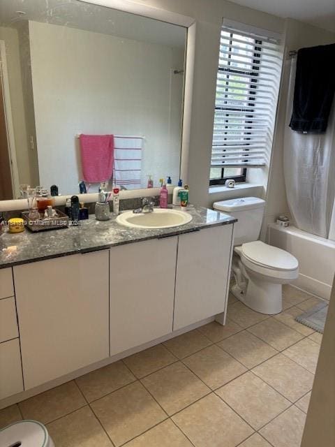 bathroom with shower / bath combo with shower curtain, vanity, toilet, and tile patterned floors