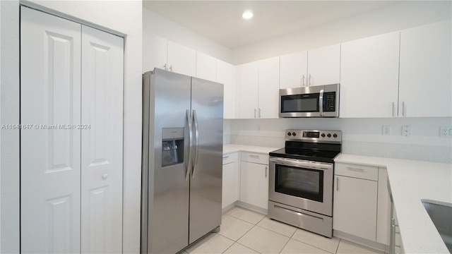 kitchen with recessed lighting, appliances with stainless steel finishes, white cabinets, light countertops, and light tile patterned floors