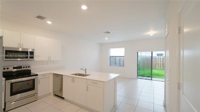 kitchen with visible vents, light countertops, a peninsula, stainless steel appliances, and a sink