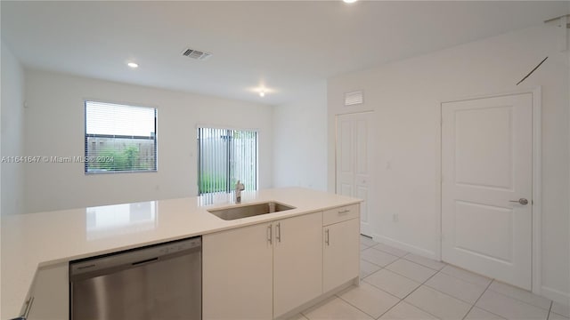 kitchen with a sink, visible vents, stainless steel dishwasher, and light countertops