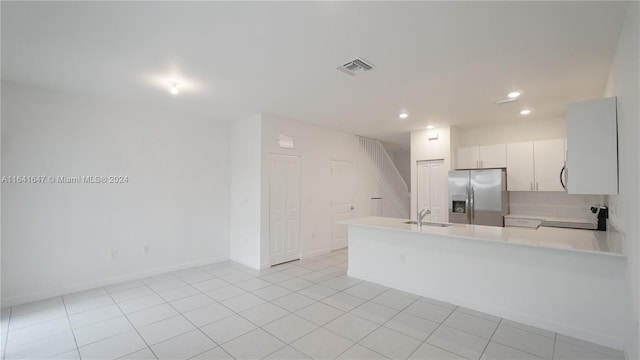 kitchen with visible vents, stainless steel fridge with ice dispenser, light countertops, a peninsula, and a sink