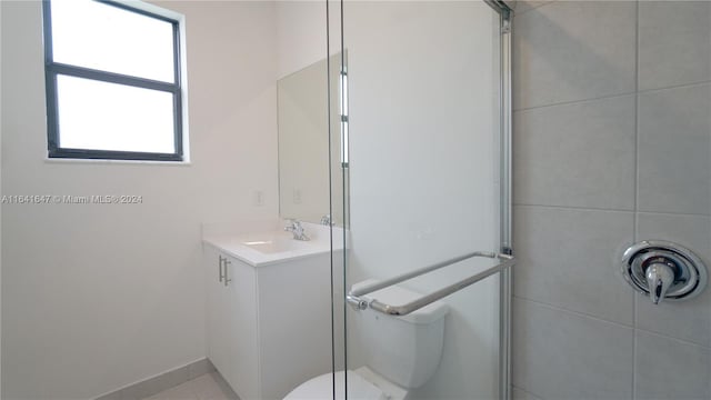 full bathroom featuring toilet, vanity, and a shower with shower door