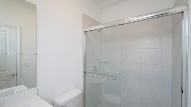 full bath with vanity, a shower stall, and toilet