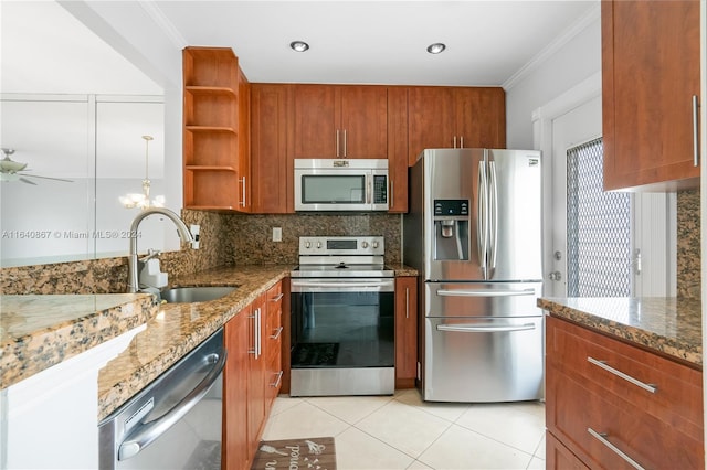 kitchen with light stone countertops, stainless steel appliances, backsplash, and sink