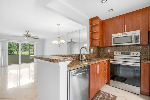 kitchen featuring sink, kitchen peninsula, stainless steel appliances, ceiling fan with notable chandelier, and crown molding