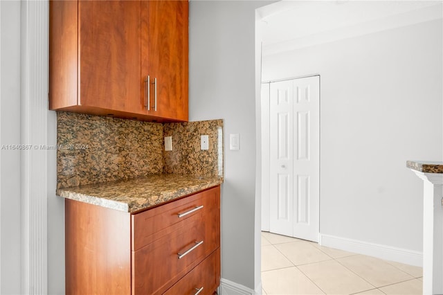 kitchen featuring dark stone counters, decorative backsplash, and light tile patterned floors