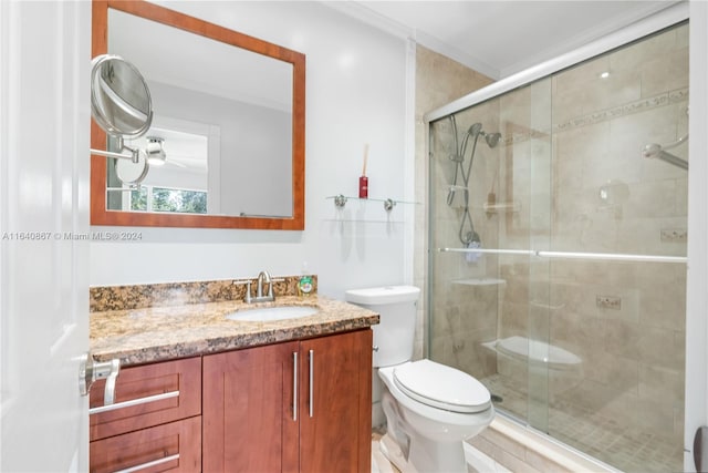 bathroom with walk in shower, crown molding, vanity, and toilet