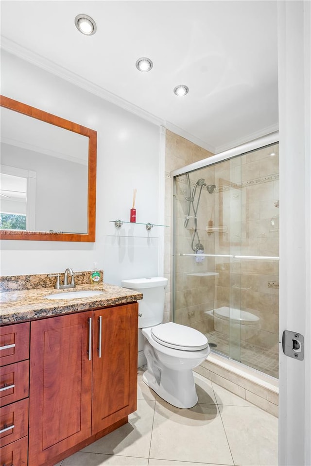 bathroom with tile patterned floors, a shower with door, vanity, and toilet