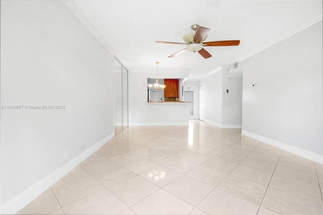 tiled spare room with ceiling fan with notable chandelier and crown molding