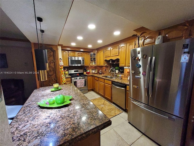 kitchen featuring backsplash, stainless steel appliances, stone counters, sink, and light tile patterned flooring