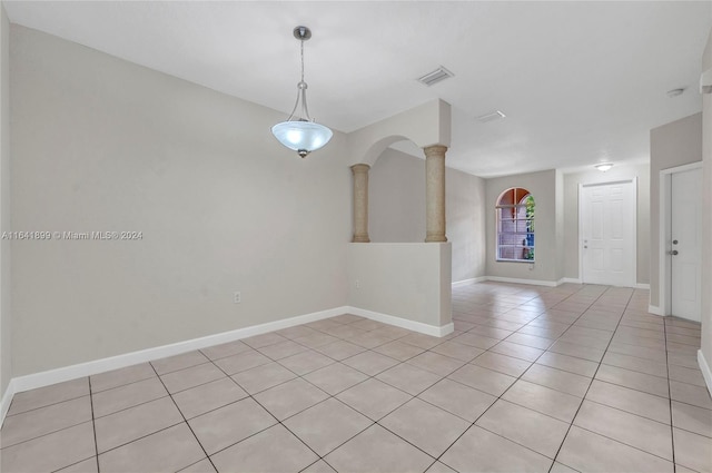 tiled empty room featuring ornate columns