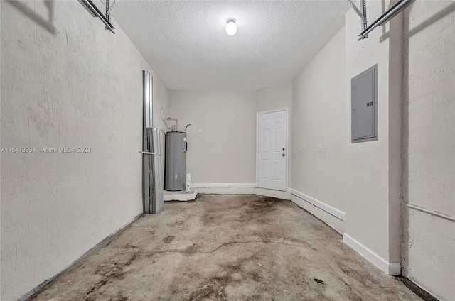 interior space with concrete flooring, electric water heater, a textured ceiling, and electric panel