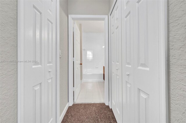 hallway featuring light colored carpet