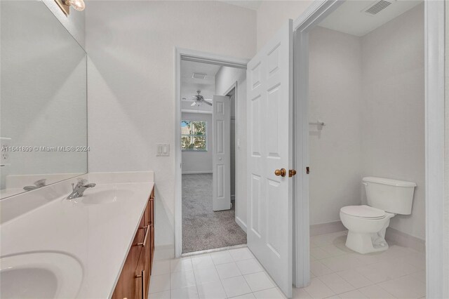 bathroom with dual vanity, ceiling fan, toilet, and tile patterned flooring