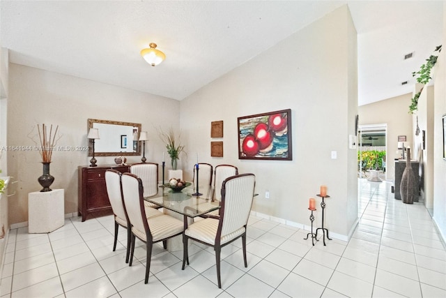 dining space with light tile patterned floors, visible vents, baseboards, and vaulted ceiling