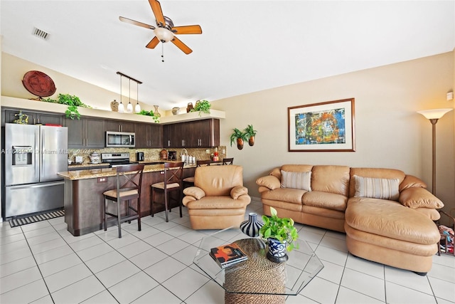 living room with light tile patterned floors, visible vents, vaulted ceiling, and ceiling fan